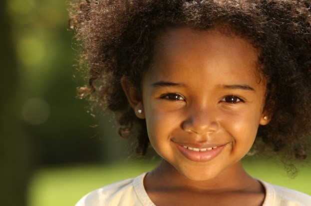 African-American girl about six years old smiling at the camera